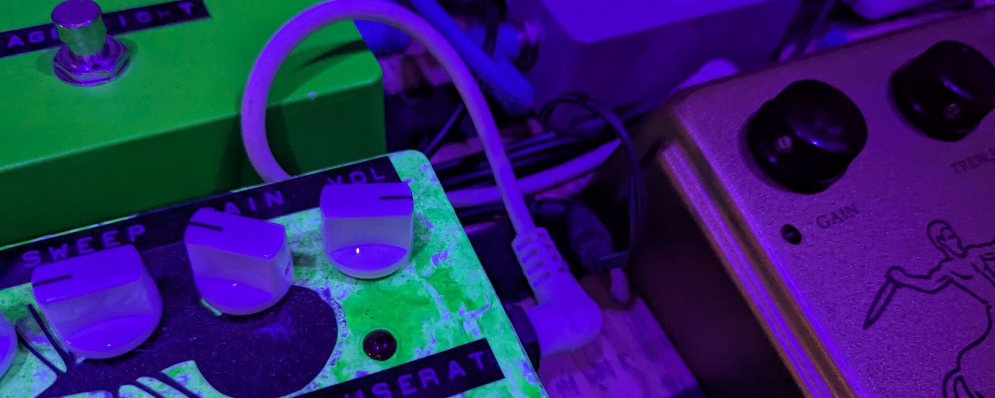 A pedal board under coloured light